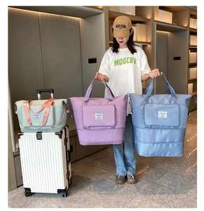 Detail of travel duffels in mint, lavender, and blue with luggage handle sleeve