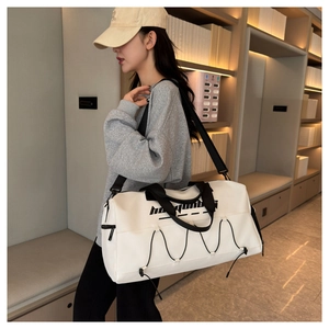 Detailed view of the large white waterproof sports tote bag worn by a model