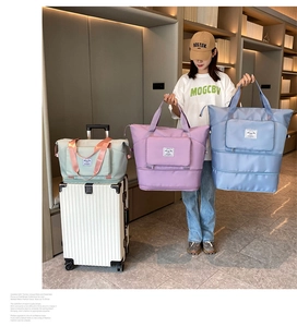 Woman holding large foldable travel bags in purple and blue colors for gym and luggage