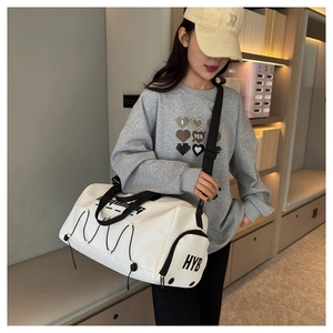 Detail view of white waterproof fitness tote bag with HYB logo and black straps