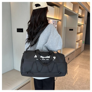 Detail of black waterproof sports bag featuring adjustable straps and stylish drawstring design