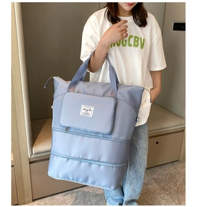Close-up of light blue travel bag with waterproof nylon texture and brand woven label