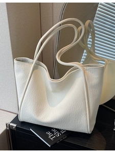 Minimalist beige pebble leather tote bag with long straps for casual daily use