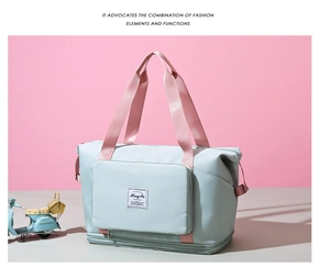 Detail of mint green waterproof travel bag with pink straps on a minimalist background