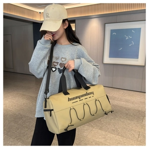 Detailed view of beige waterproof fitness bag with adjustable shoulder straps and handles