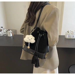 Detail of black patchwork bucket bag with drawstring tassels and white cloud charm