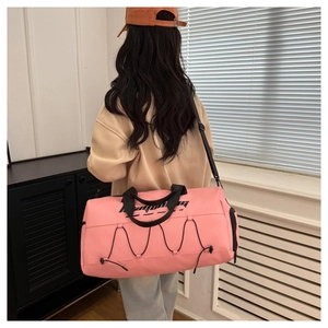 Rear view of model wearing pink waterproof sports bag with crossbody strap and logo detail