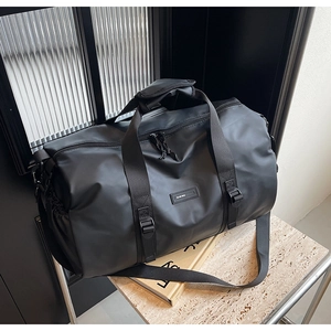 Macro shot of waterproof black Oxford travel bag with reinforced handles and brand logo