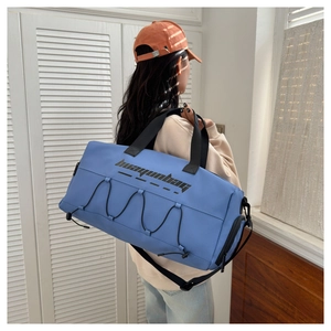 Blue fitness bag with adjustable shoulder strap shown in a home gym setting