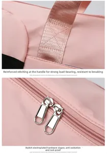 Detail of reinforced stitching on pink travel bag handles and dual gold metal zippers