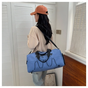 Close-up of blue waterproof travel bag with adjustable strap and elastic drawcord detail