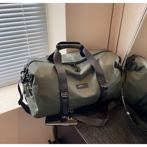 Detail of dark green oxford fabric travel bag with adjustable strap and waterproof texture