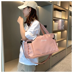 Pink large-capacity nylon travel bag shown on shoulder in a lifestyle setting