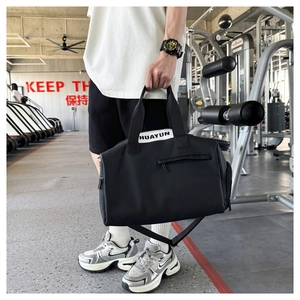 Detalle de la bolsa de deporte negra duradera con correas blancas en un gimnasio real
