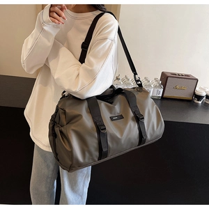 Detail view of large olive green oxford travel bag with adjustable strap on a female model