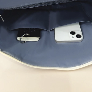 Interior detail of navy blue travel bag showing two inner pockets with phone and notebook