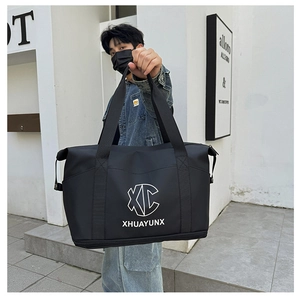 Detail of waterproof black travel bag with double handles and separate shoe compartment