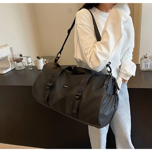 Detail view of black oxford travel bag featuring reinforced handles and buckle closures
