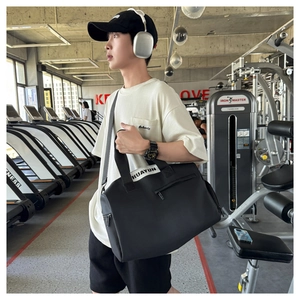 Detalle de una bolsa de gimnasio negra de gran capacidad con correa de hombro ajustable