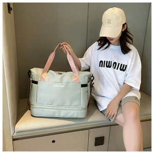 Close-up of mint green travel tote with pink handles and separate bottom compartment