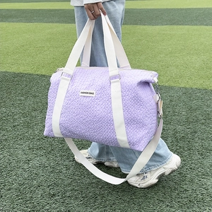 Close-up of purple bubble textured travel bag featuring durable white woven handles