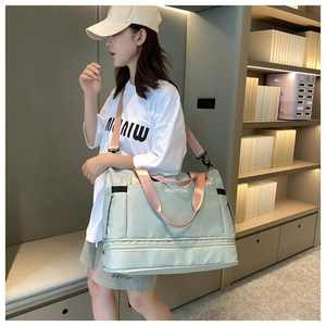 Detail of mint green travel bag featuring adjustable pink strap and waterproof fabric