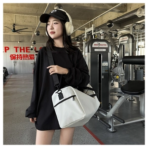 Detalle de bolsa deportiva blanca con cremalleras negras y correa de hombro desmontable