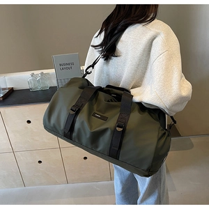 Green oxford fabric travel bag shown on shoulder in a modern business interior