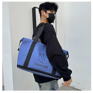 Deep blue travel bag featuring a bottom shoe compartment shown in a lifestyle male model view