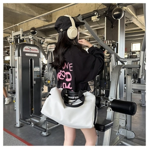 Vista lateral de la gran bolsa de deporte blanca con correas en un entorno de gimnasio