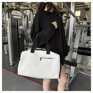 Detalle de bolsa de deporte impermeable con correas negras en contraste y logo Huayun