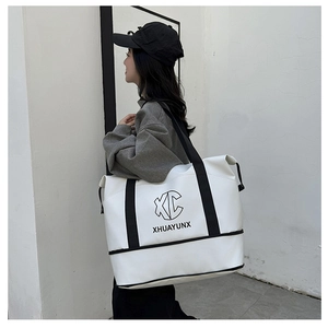 Close-up of white travel bag with black logo and trolley sleeve for suitcase attachment