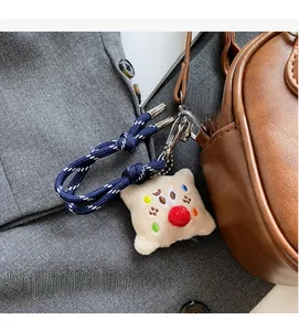 Détail d'un bijou de sac en peluche brodé sur un sac à bandoulière en cuir