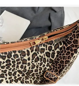 Détail de la fermeture éclair dorée et du tissu imprimé léopard sur un sac fourre-tout