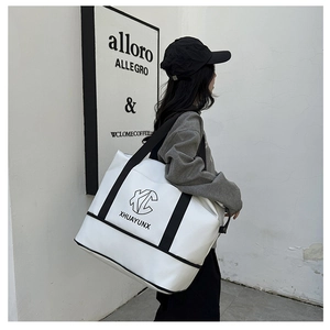Close-up of white tote bag with black XHUAYUNX logo and reinforced bottom piping