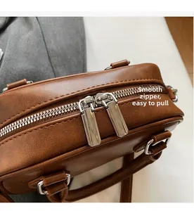 Détails de la double fermeture éclair argentée sur un sac à main en cuir marron