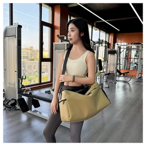 Detalle de bolsa de deporte caqui con tela resistente, cremalleras negras y correa ajustable