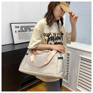 Detailed view of lightweight nylon travel bag with pink handles and shoe compartment
