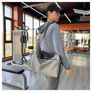 Detalle de bolsa de deporte gris resistente con correas de nailon en gimnasio