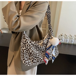 Détail du sac cabas léopard avec accessoire foulard en soie et breloque boule en peluche