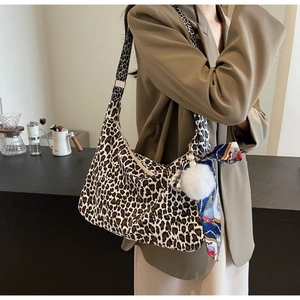 Détail du sac cabas léopard avec pompon en peluche et foulard en soie décoratif