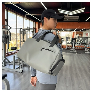Detalle macro de una bolsa de deporte gris claro impermeable con asas reforzadas y bolsos