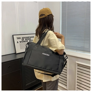 Black large capacity travel bag worn over the shoulder featuring adjustable strap and logo