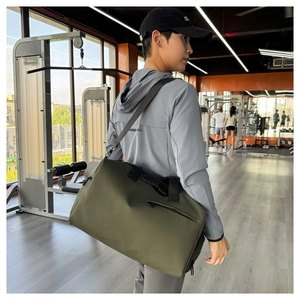 Bolso deportivo verde oliva con correa ajustable negra llevado por un modelo masculino