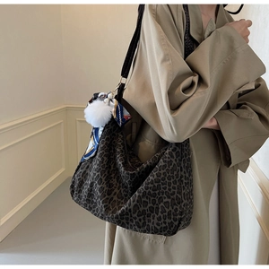Détail du sac cabas léopard avec foulard décoratif en soie et pompon blanc doux