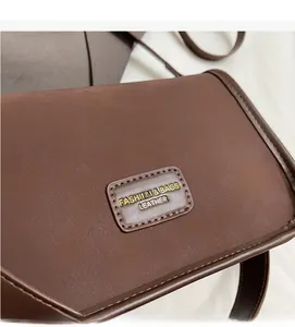 Close-up of dark brown leather pillow bag featuring fashion logo and fine stitching