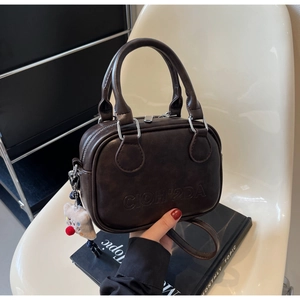Détail du mini sac Boston marron café avec lettrage embossé et charmant petit ours
