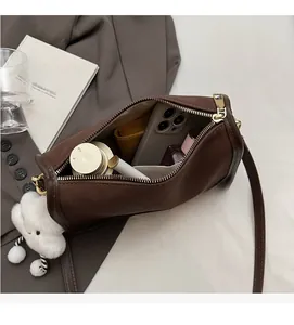 Interior view of brown cylindrical crossbody bag showing storage capacity for essentials