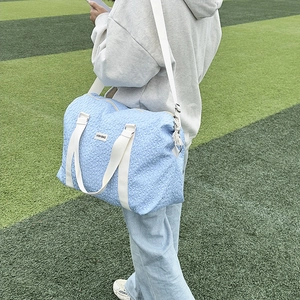 Close-up of light blue travel bag featuring unique 3D texture and Fashion Bag label