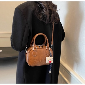 Détail du sac bandoulière vintage en cuir PU marron avec gaufrage et breloque en peluche